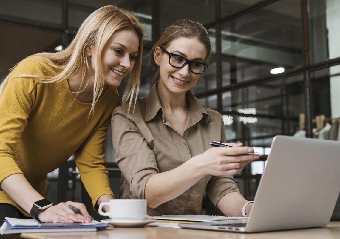 young-smiley-businesswomen-working-with-laptop-desk